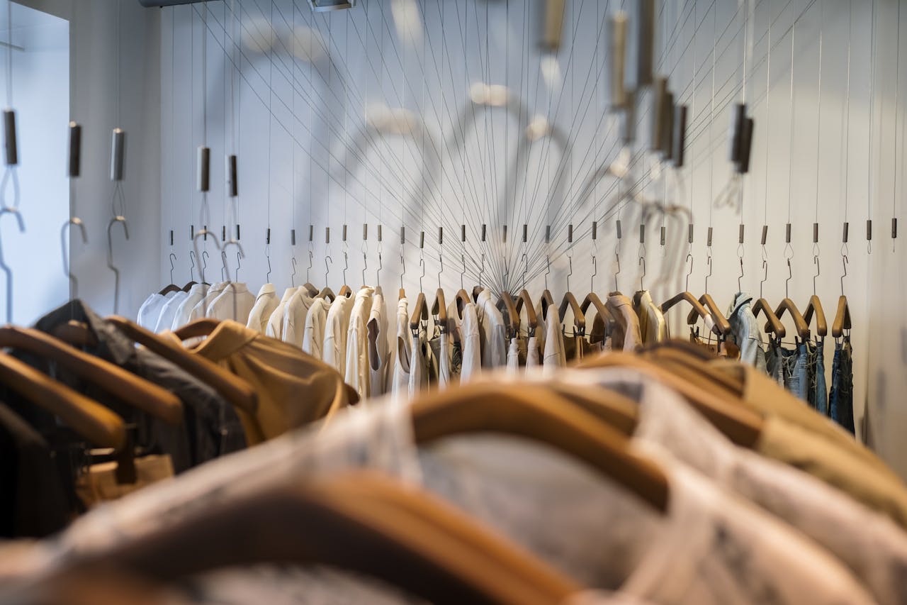 A diverse collection of clothes neatly arranged on hangers in a trendy boutique setting.